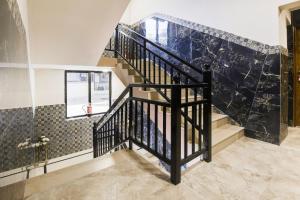 a staircase with black railings and a tile wall at Super Hotel O Dabolim Near Goa International Airport in Goa