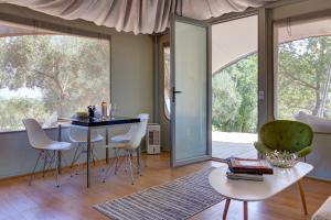 a living room with a table and chairs and large windows at Amavi Luxury Tent Corfu in Víngla