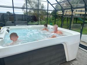 three children in a hot tub in at Double Ensuite Ground Floor Easy to Cardiff in Cardiff +1 photo
