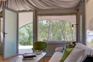 a living room with a couch and a large window at Amavi Luxury Tent Corfu in Víngla +14 photos