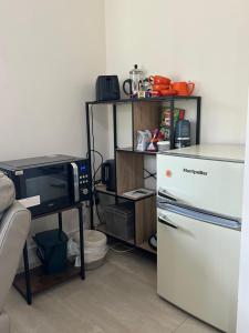 a kitchen with a microwave and a refrigerator at Double Ensuite Ground Floor Easy to Cardiff in Cardiff