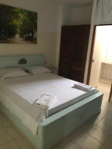 a bedroom with a bed with white sheets and a window at Maio Relax in Vila do Porto