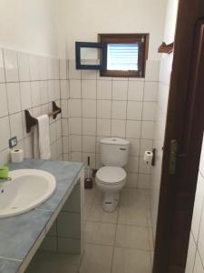 a bathroom with a toilet and a sink and a window at Maio Relax in Vila do Porto +36 photos