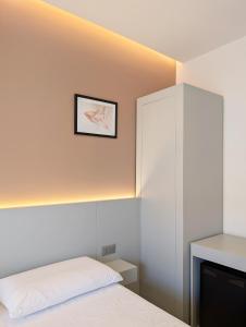 a bedroom with a white bed and a cabinet at The Superhost - IL Lux in Crotone