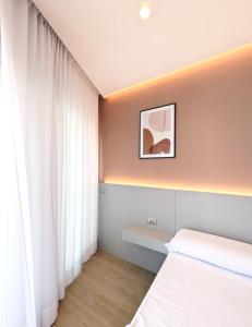 a bedroom with white curtains and a white bed at The Superhost - IL Lux in Crotone