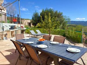 a blue table and chairs on a patio with a table and chairs at St Visianos stone house in Philousa