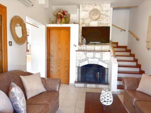 a living room with a couch and a fireplace at St Visianos stone house in Philousa
