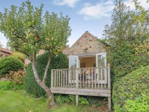 a house with a porch and an apple tree at 1 Bed in York oc-g0032 in Crayke
