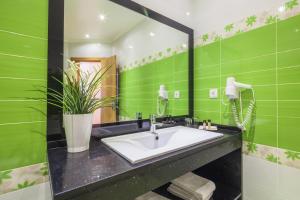 a green bathroom with a sink and a mirror at Vila Nova Guesthouse in Lisbon