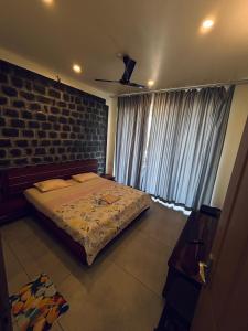 a bedroom with a bed and a brick wall at Horizon house in Vagamon