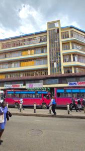 people walking on a street in front of a building at Triple SSS Hotel in Nairobi
