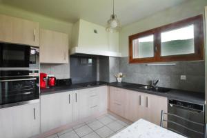a kitchen with white cabinets and black counter tops at Charming house with great views in Brison-Saint-Innocent