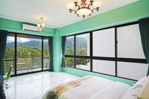 a bedroom with green walls and large windows and a bed at Mao Lan Mountain Holiday Villa in Shan-tzu-chiao