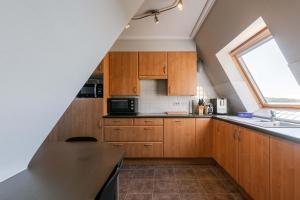 a kitchen with wooden cabinets and a window at Casiola - Comfortable Apartment with Scenic Views in De Haan