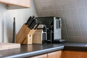 a kitchen counter with a knife block and a microwave at Casiola - Comfortable Apartment with Scenic Views in De Haan +24 photos
