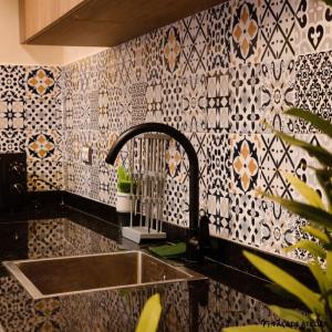 a kitchen with a sink and a patterned wall at Le Calme a Temara in Temara +74 photos