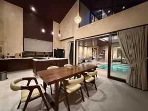 a kitchen and dining room with a wooden table and chairs at Eden Villas Lombok in Kuta Lombok