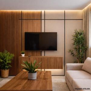a living room with a television on a wall at Le Calme a Temara in Temara