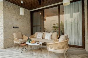 a patio with wicker chairs and a couch and a table at Lindsay Manor AkSh Private Pool 4BHK Lift in Arpora