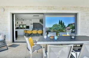 a kitchen and dining room with a table and chairs at Villa Mila in Vabriga