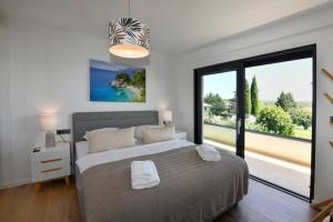 a bedroom with a large bed and a large window at Villa Mila in Vabriga +40 photos