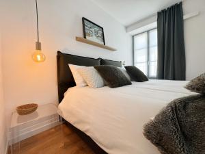 a bedroom with a large white bed with a window at Carducci Holiday Home in Chiavenna