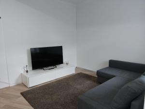 a living room with a couch and a flat screen tv at HOME City Stay Chemnitz in Chemnitz