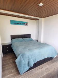 a large bed in a bedroom with a wooden ceiling at Volterra Guatavita in Guatavita