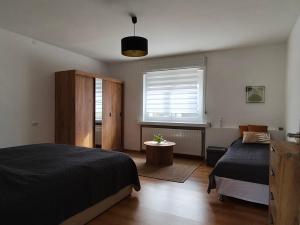 a bedroom with two beds and a window at Fészek Vendégház in Zalaegerszeg