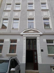 a white building with a door in front of it at HOME City Stay Chemnitz in Chemnitz
