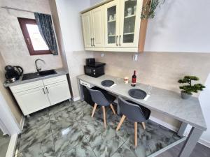 a kitchen with a table and chairs and a sink at Central Residence Targu Mures in Târgu-Mureş