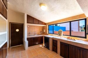a large kitchen with wooden cabinets and a large window at 4000 - Casa San Felipe in Oaxaca City