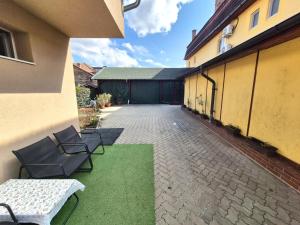 a courtyard of a building with two chairs and grass at Central Residence Targu Mures in Târgu-Mureş
