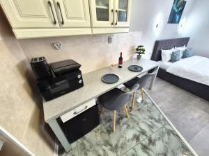 a kitchen with a table with two chairs and a bed at Central Residence Targu Mures in Târgu-Mureş