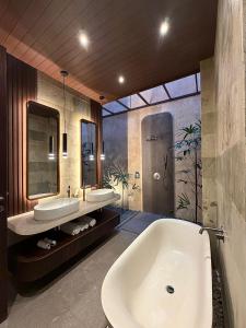 a large bathroom with two sinks and a tub at Eden Villas Lombok in Kuta Lombok
