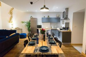 a dining room with a table and a kitchen at AppartUnique - Chez Helder - Standing, Calme & Design in Vichy +10 photos