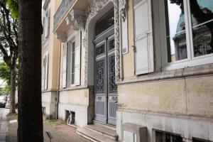a building with an open door on a street at AppartUnique - Chez Helder - Standing, Calme & Design in Vichy