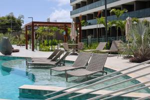 a row of chairs sitting next to a swimming pool at Luxury Flat with Breakfast! in Ipojuca