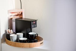 a coffee station with coffee cups and a microwave at OIKO MINI SUITES in Ermoupoli