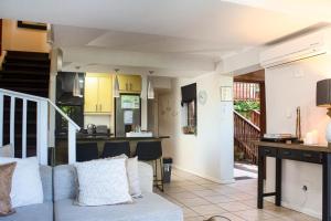 a living room with a couch and a kitchen at The Milkwood House in Wilderness