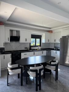 a kitchen with a table and chairs and a refrigerator at Tekirova DOM Villas with Heated Pool in Kemer