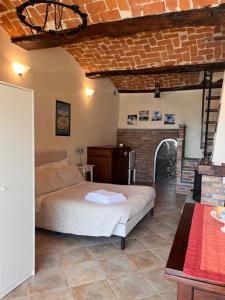 a bedroom with a bed and a brick wall at An tij slè - Nel cuore del borgo in Guarene