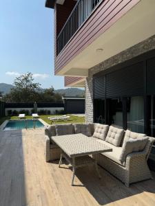 a patio with a couch and a table on a patio at Tekirova DOM Villas with Heated Pool in Kemer