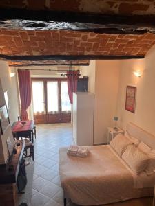 a living room with a bed and a table at An tij slè - Nel cuore del borgo in Guarene