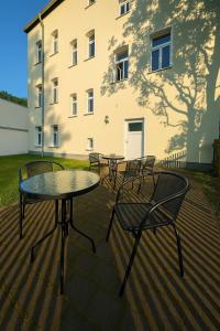 a group of tables and chairs in front of a building at Komfortzimmer Waldheim in Waldheim