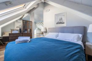 a bedroom with a large bed with a blue blanket at Alassio White Loft in Alassio