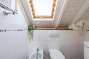 a bathroom with a toilet and a window at Alassio White Loft in Alassio +26 photos