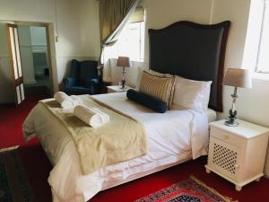 a bedroom with a large bed with white sheets and pillows at Klaarstroom Hotel in Klaarstroom