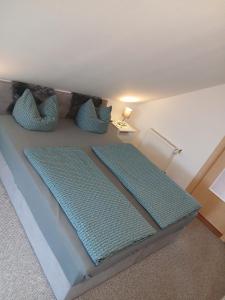a bed with blue pillows on it in a room at Kranich in Wieck
