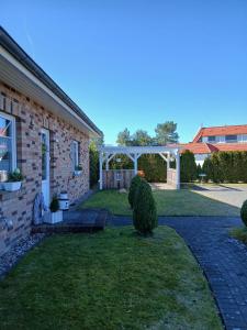 a backyard with a pergola and a brick house at Kranich in Wieck